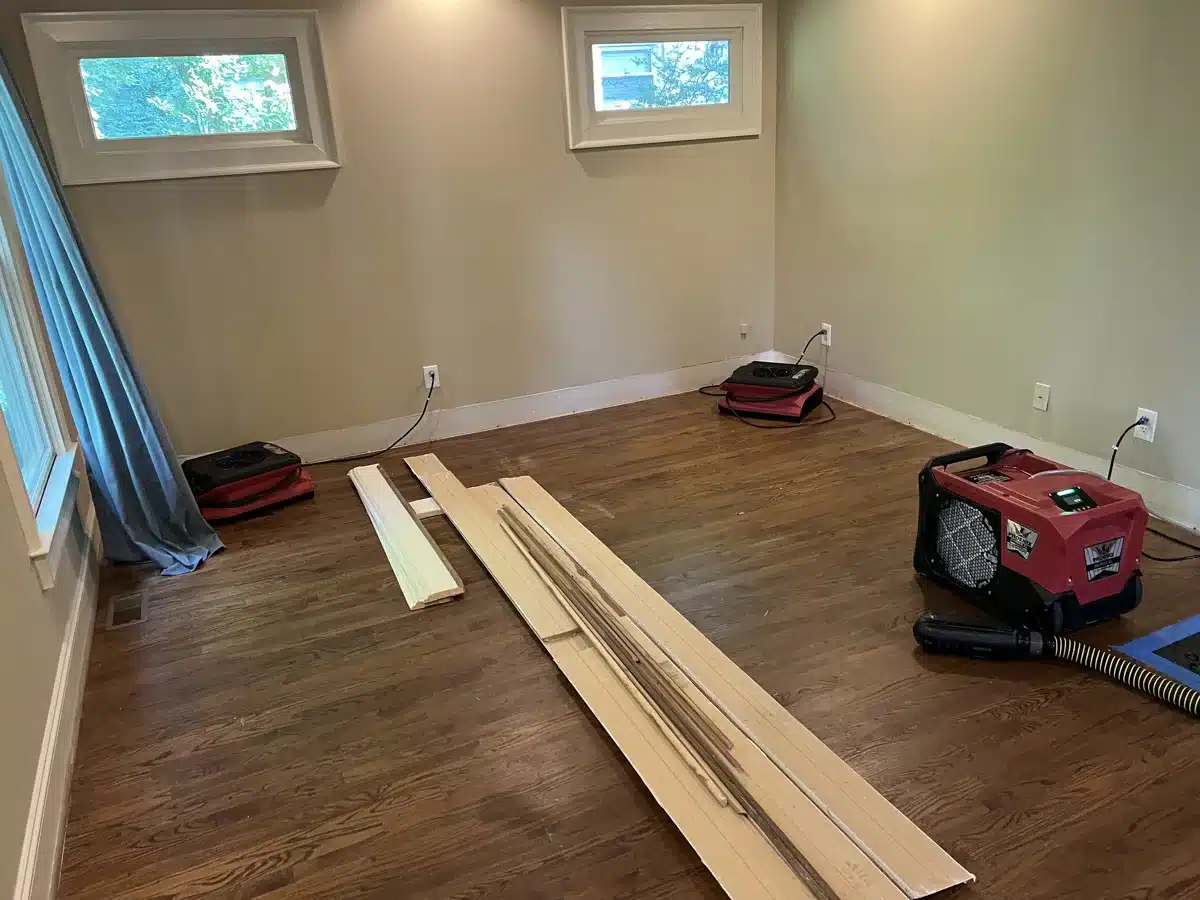 Air movers and dehumidifier drying hardwood floor room