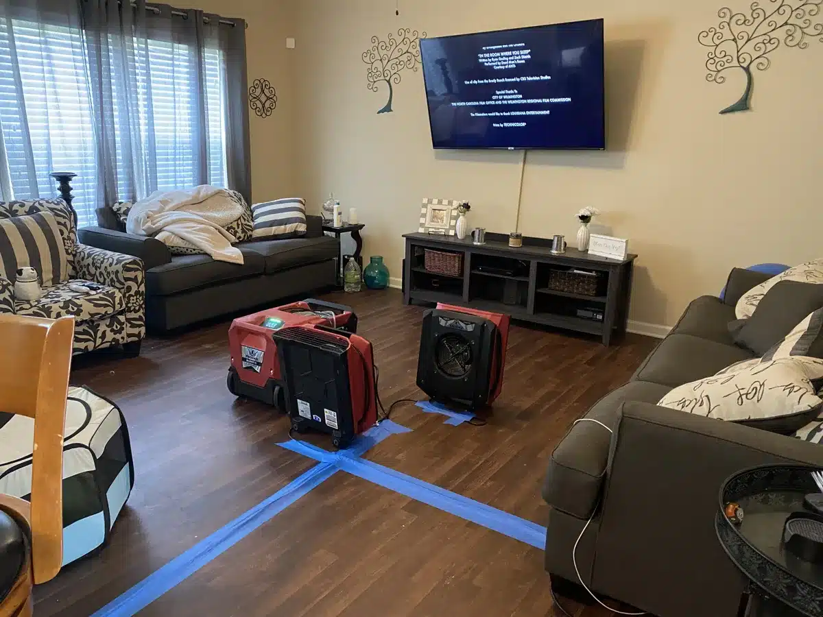 Air movers and dehumidifier drying living room floor