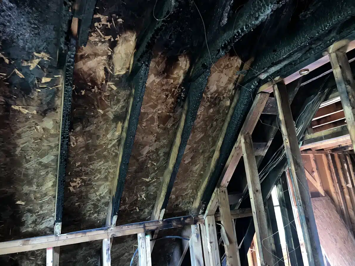 Charred roof rafters and sheathing after fire damage