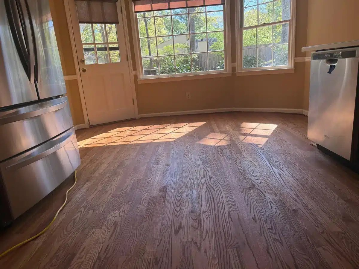 Restored hardwood floor in bright kitchen dining area