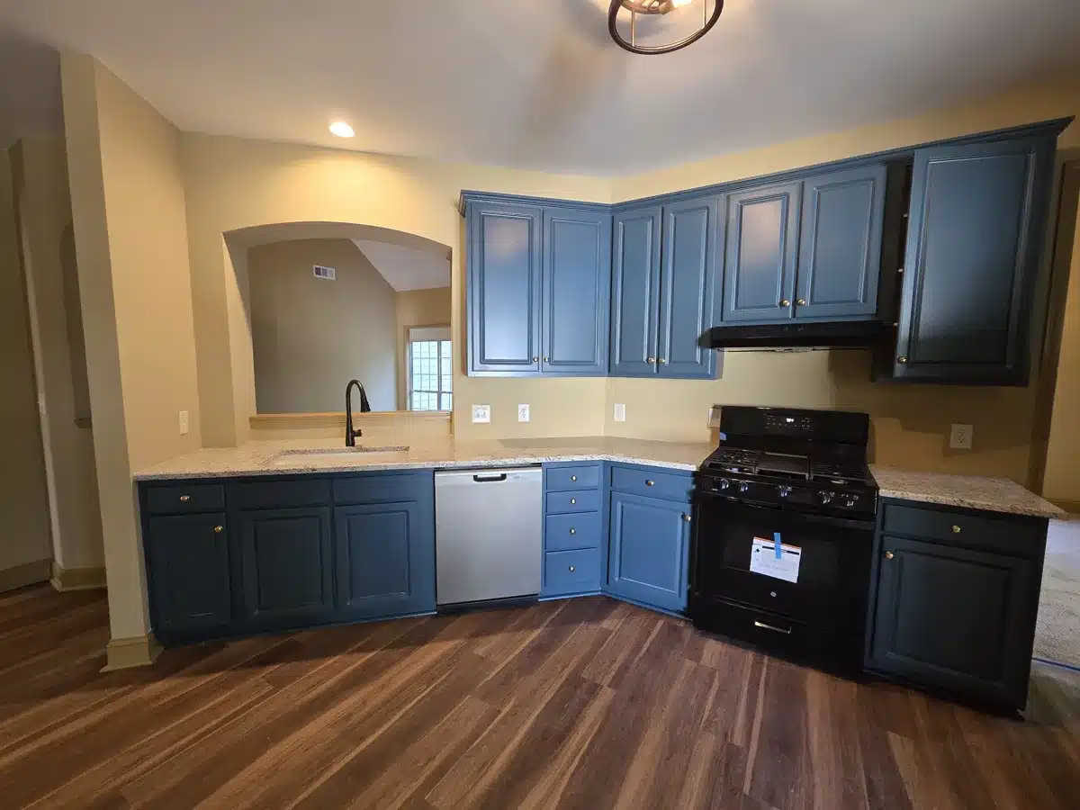 Restored kitchen with blue cabinets and new appliances
